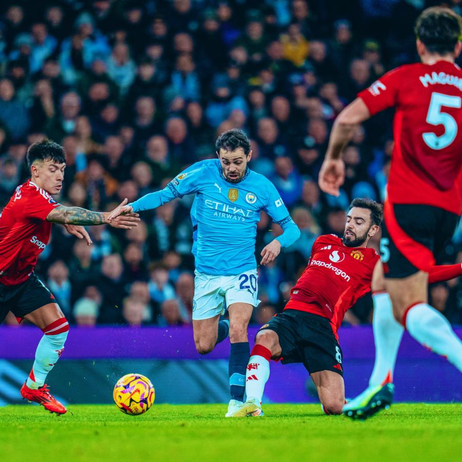 Imagen Bernardo Silva pasa entre Lisandro Martínez y Bruno Fernández. El derbi de Manchester se resolvió sobre el final.